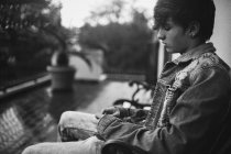 Мальчик-подросток сидит на скамейке — стоковое фото
