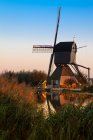Moulin à vent sur le canal au coucher du soleil, Kinderdijk, Pays-Bas — Photo de stock