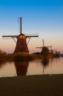 Windmühlen über dem Wasserkanal bei Sonnenuntergang, Kinderdijk, Niederlande — Stockfoto