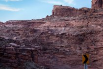 Voiture le long d'une falaise dans un paysage désertique, Amérique, États-Unis — Photo de stock