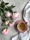 Vista da vicino delle peonie rosa con una tazza di tè — Foto stock