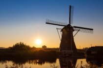 Kinderdijk is a village in the Netherlands, belonging to the municipality of Molenwaard, in the province South Holland, about 15 km (9 miles) east of Rotterdam. Kinderdijk is situated in a polder in the Alblasserwaard at the confluence of the Lek and — Stock Photo