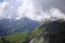 Paisaje montañoso rocoso con lago y cielo nublado - foto de stock