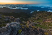 Красивий гірський пейзаж з низькими хмарами і заходом сонця — стокове фото