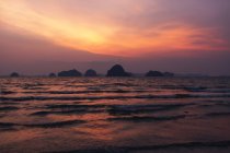 Rochas sobre ondas de mar rolando e belo céu por do sol — Fotografia de Stock