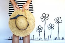 Visão traseira de uma mulher com um pincel olhando para flores pintadas — Fotografia de Stock