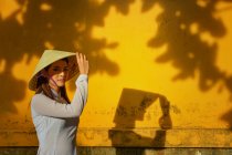 Retrato de una mujer tocándose el sombrero, Vietnam - foto de stock