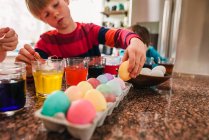 Two boys standing in the kitchen dying Easter eggs — Stock Photo