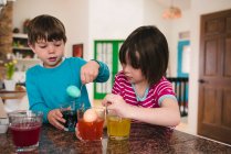 Boy and girl  standing in the kitchen dying Easter eggs — Stock Photo