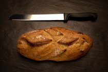 Хлібний хліб з ножем над столом — стокове фото