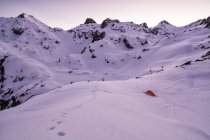 Tienda roja en las montañas cubiertas de nieve, Parque Nacional de los Pirineos, Francia - foto de stock