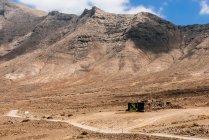 Scenic view of Winding road towards the mountains, Cofete, Fuerteventura, Canary Islands, Spain — стоковое фото