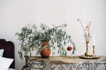 Ветки в вазе со свечой на тумбочке — стоковое фото