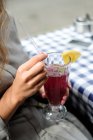 Женщина в кафе пьет клюквенный коктейль — стоковое фото