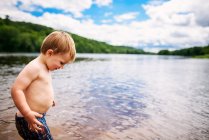 Ritratto di un bambino in piedi vicino a un fiume in estate — Foto stock