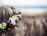 Menina com cabelo comprido usando uma cobertura para a cabeça de flor — Fotografia de Stock