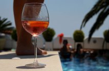 Склянка трояндового вина біля краю басейну на вечірці біля басейну — стокове фото