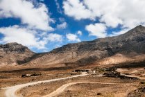 Scenic view of Winding road towards the mountains, Cofete, Fuerteventura, Canary Islands, Spain — стоковое фото