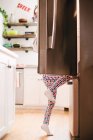 Молода дівчина піднімається в холодильник — стокове фото