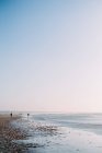 Silhouettes de personnes marchant sur la plage, ijmuiden, holland — Photo de stock