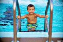 Мальчик выходит из бассейна — стоковое фото
