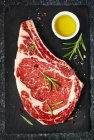 Roh gealtertes Steak auf schwarzem Hintergrund, Draufsicht — Stockfoto