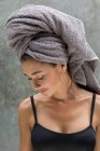 Eine junge Frau mit grauem Kopftuch bereitet sich nach einer Dusche in einer tropischen balinesischen Villa auf ihre Gesichtsmaske vor. — Stockfoto
