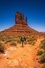 Navajo Tribal Park orange red landscape, tourist man walking on path way — Stock Photo