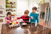 Kleine Kinder färben Ostereier — Stockfoto