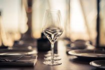 Table setting with champagne flutes in line — Stock Photo