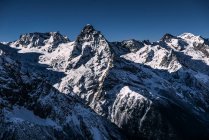 Belas montanhas cobertas de neve em luz solar brilhante — Fotografia de Stock