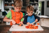 Due bambini che aiutano a cucinare in cucina — Foto stock