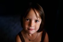 Портрет усміхненої дівчини на темному тлі — стокове фото