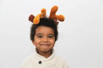Portrait of a smiling boy wearing Christmas antlers — Stock Photo