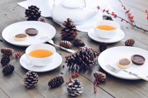 Різдвяна композиція з чашками напоїв на дерев'яній поверхні — стокове фото