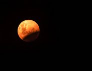Червоний місяць в чорному нічному небі — стокове фото