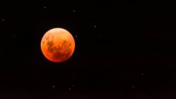Red moon in black night sky — Stock Photo