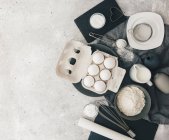 Ingredients for baking and kitchen utensils on a gray background. top view. — Stock Photo