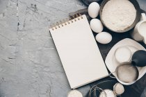 Ingredients for baking. top view of different types of eggs, flour, rolling pin, whisk, white — Stock Photo