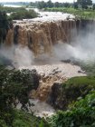Cachoeira enorme com água suja cercada de vegetação — Fotografia de Stock