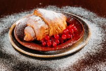 Nahaufnahme von süßem Croissant mit roten Johannisbeeren — Stockfoto