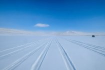 Reifenspuren im Schnee und ein geparktes Fahrzeug, Baikalsee, Gebiet Irkutsk, Sibirien, Russland — Stockfoto