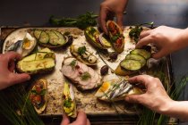Чотири людини їдять відкриті бутерброди — стокове фото