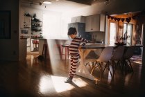 Хлопчик танцює на кухні в піжамах — стокове фото