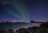Vista panorámica de las luces boreales sobre las montañas, Napp, Flakstad, Nordland, Noruega - foto de stock