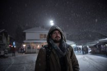 Retrato de um homem de pé em uma rua da cidade na neve — Fotografia de Stock