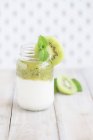 Um pote de iogurte natural com kiwi e hortelã fresca — Fotografia de Stock