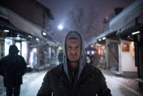 Retrato de um homem de pé em uma rua da cidade na neve — Fotografia de Stock