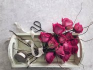 Bouquet of roses on a tray with ribbon and scissors — Stock Photo
