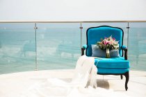 Свадебное платье и свадебный букет на кресле — стоковое фото